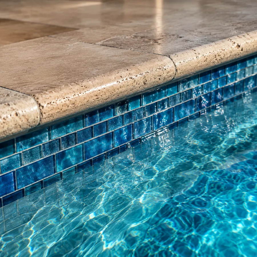 Glass mosaic waterline tile and travertine coping